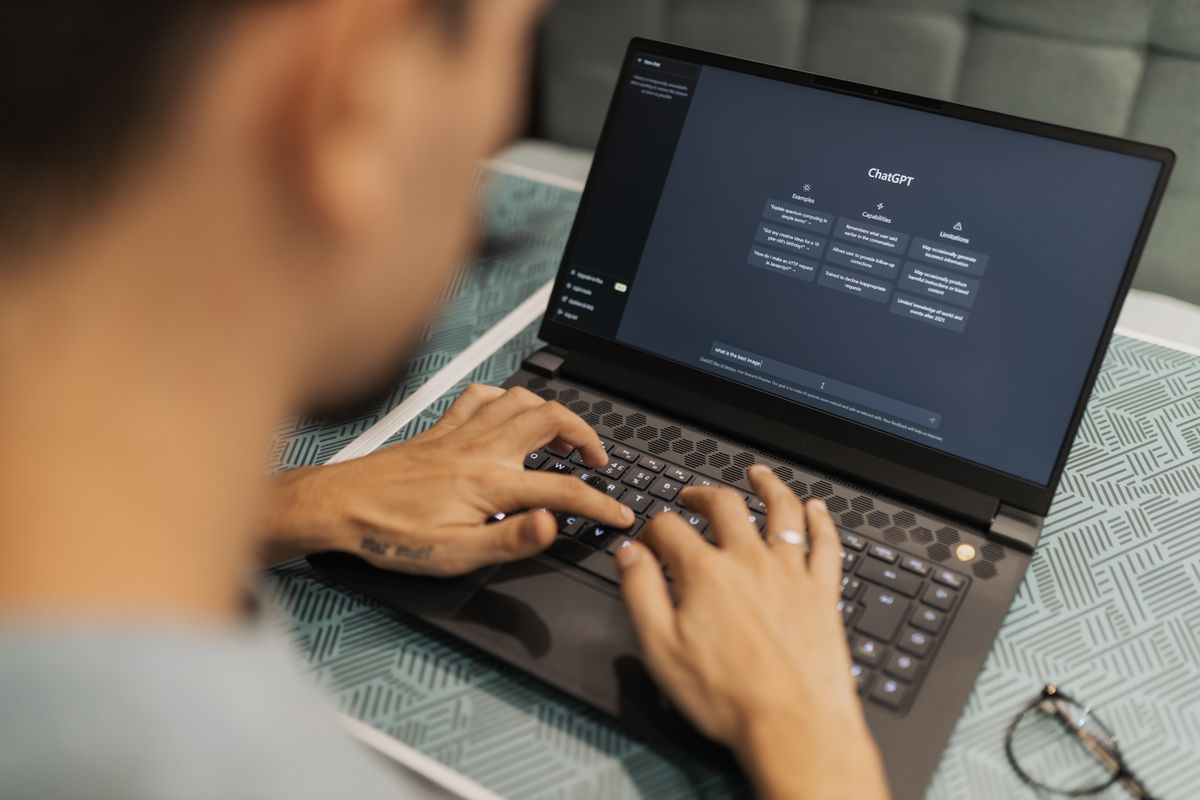 Laptop specs for AI — person using an AI chat assistant on a laptop